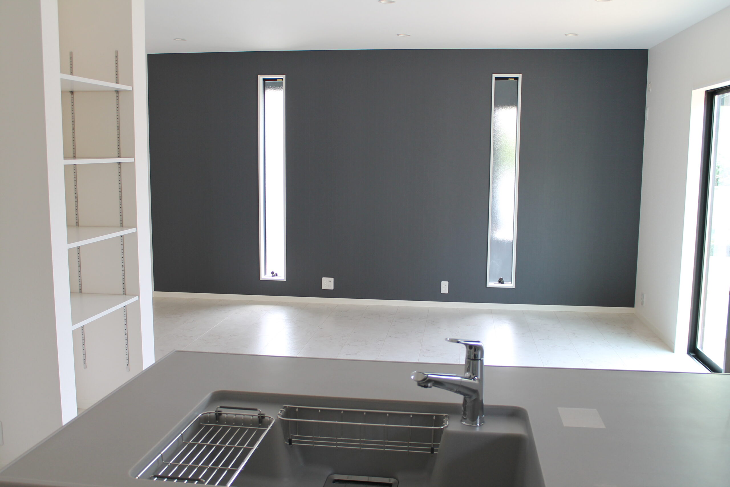 黒のアクセントウォールを設けた新築住宅のLDK