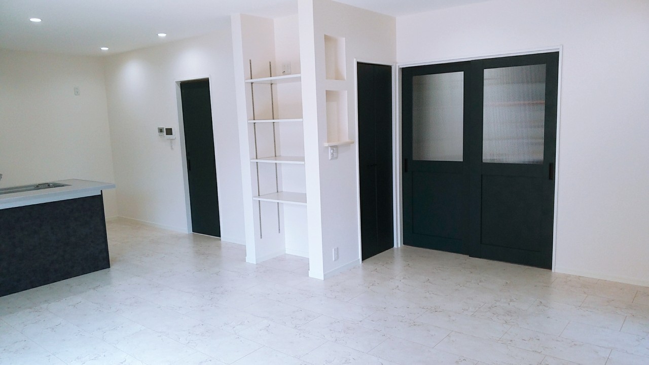 黒い建具と造作棚を取り入れた新築住宅のリビング